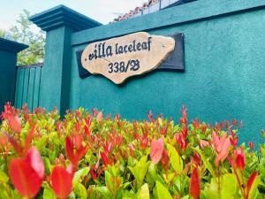 a sign on the side of a building with flowers at Villa Laceleaf in Induruwa +4 photos