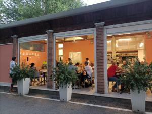 a group of people sitting at tables in a restaurant at CAMPING CALATELLA parco di vacanza in Marina di Massa