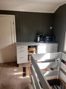 a kitchen with white cabinets and a counter top at Koia Guesthouse in Flesberg