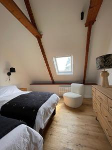 a bedroom with a bed and a chair and a window at Villa Mamina, face à la mer, île Grande in Pleumeur-Bodou