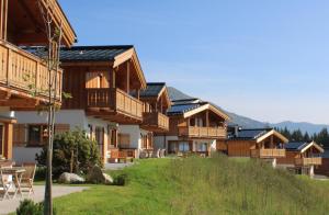 une rangée de maisons en bois avec des panneaux solaires sur leurs toits dans l'établissement Filzsteinresort Chalets Chalet Bergankunft 236, à Krimml