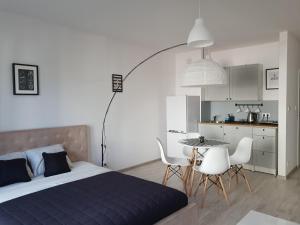 una camera da letto con un letto, un tavolo e delle sedie di White Studio V a Władysławowo