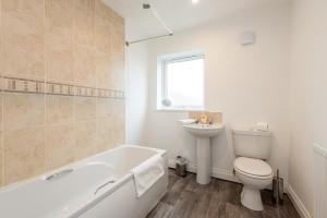 a bathroom with a tub and a toilet and a sink at Brancepeth Place in Shildon +12 photos