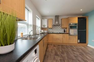 a kitchen with wooden cabinets and a black refrigerator at Brancepeth Place in Shildon