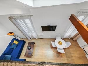Una sala de estar con un sofá azul y una mesa. en Loft Duplex à 2 min de Paris - Parking gratuit, en Le Pré-Saint-Gervais 43 fotos más