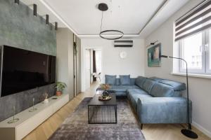 a living room with a blue couch and a tv at Designer's Retreat in Buda in Budapest
