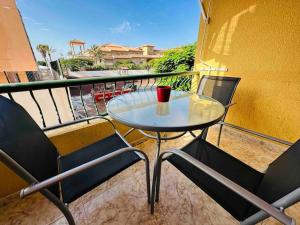 a glass table and chairs on a balcony at Las Vistas Beach Los Cristianos 2 Swimming Pools in Los Cristianos