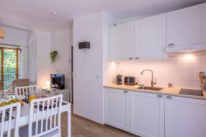 une cuisine avec des armoires blanches et un comptoir dans l'établissement Les Charmes C38 - Le Val Joly, à Eppe-Sauvage 4 autres photos