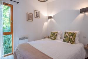 une chambre avec un lit avec des draps blancs et une fenêtre dans l'établissement Les Charmes C38 - Le Val Joly, à Eppe-Sauvage