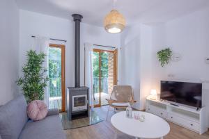 un salon avec une cheminée et une télévision dans l'établissement Les Charmes C38 - Le Val Joly, à Eppe-Sauvage