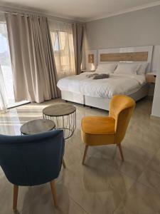 a bedroom with a bed and a chair and a couch at Sekret Zone Hotel in New Germany