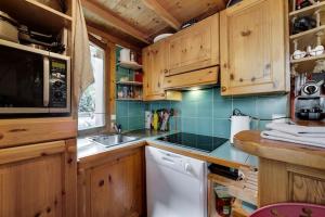 ヴァル・ディゼールにあるChalet Barme de l'Ours 1のキッチン(木製キャビネット、白い食器洗い機付)