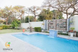 a swimming pool in a yard with a fence at Sunpalm Guesthouse in Nelspruit