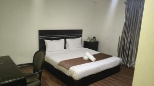 a bedroom with a large bed with white sheets and pillows at Bluebell Hotel skudai in Kempas