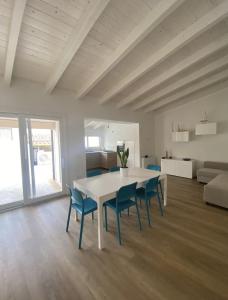 a dining room with a white table and blue chairs at Villa Stefania in Magomadas