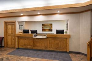 a lobby with a reception desk with two computers on it at Days Inn & Suites by Wyndham Bozeman in Bozeman +34 photos
