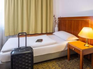A bed or beds in a room at Hotel Mercure Wien Westbahnhof