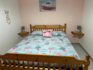 a bedroom with a bed with a pink flamingo bedspread at Villaggio Malfidano in Buggerru