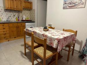 a kitchen with a table and chairs with a table cloth at Villaggio Malfidano in Buggerru