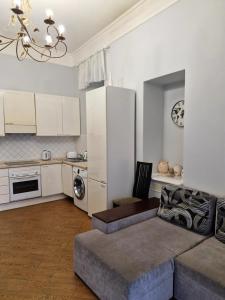a living room with a couch and a kitchen at Затишна квартира на Майдані Незалежності in Kyiv