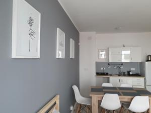 Una cocina y un comedor con mesa y sillas. en Apartament Grey Goose V, en Władysławowo