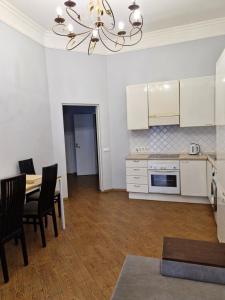 a kitchen and dining room with a table and a chandelier at Затишна квартира на Майдані Незалежності in Kyiv +7 photos