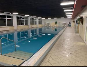 a large indoor swimming pool with blue water at Apartment am Rodelberg in Braunlage