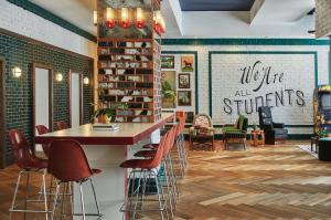 a library with a table and chairs and bookshelves at Graduate by Hilton Lincoln in Lincoln