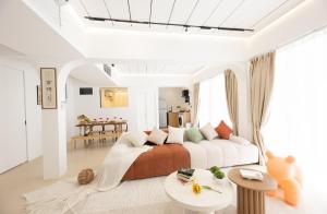 バンコクにあるRatchada Retreat Boutique Suitesのベッドとテーブルのある白い部屋