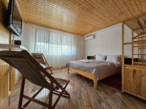 a bedroom with a bed and a wooden ceiling at Casuta Noastra - Sulina in Sulina
