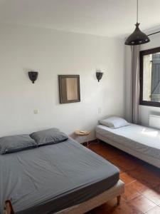 una camera da letto con due letti e una finestra di Sartène - Villa - 16 pers - 8 pièces - 6 chambres a Foce