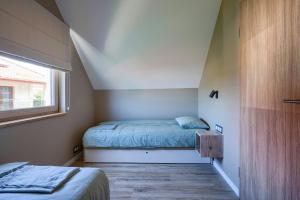 a small bedroom with a bed and a window at Jesionowa 3 Domki in Rowy