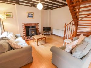 a living room with two couches and a fireplace at 2 Cheriton Cottages in Pembroke