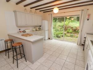a kitchen with white cabinets and a large window at 2 Cheriton Cottages in Pembroke