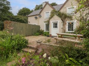 a house with a picnic table and a fence at 2 Cheriton Cottages in Pembroke