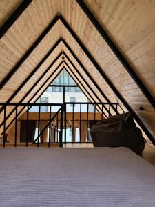 a bed in a room with a large window at Outdoor Cottages Kazbegi in Stepantsminda