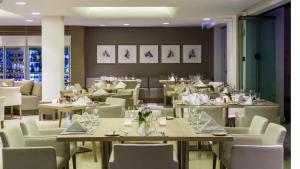 a dining room with tables and white chairs at Alasia Boutique Hotel in Limassol