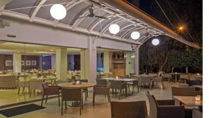 a restaurant with tables and chairs and lights at Alasia Boutique Hotel in Limassol