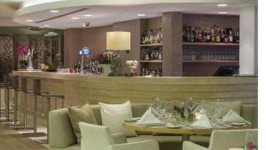 a dining room with a table and a bar at Alasia Boutique Hotel in Limassol