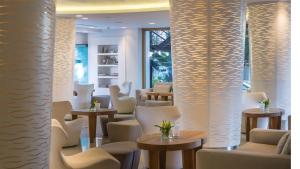 a restaurant with white chairs and tables and windows at Alasia Boutique Hotel in Limassol