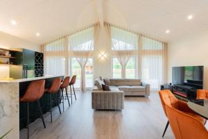 a living room with a couch and a bar with chairs at Kolmnurga Villa in Audru
