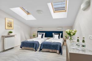 two beds in a attic room with a skylight at Hotel Witkowski Warsaw Airport in Warsaw