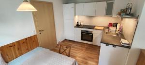 a small kitchen with white cabinets and a table at Ferienwohnung Elisabeth Laimer in Bad Goisern