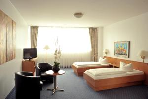 a hotel room with two beds and a tv at Hotel Ludwig van Beethoven in Berlin