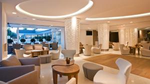 a hotel lobby with white chairs and tables at Alasia Boutique Hotel in Limassol