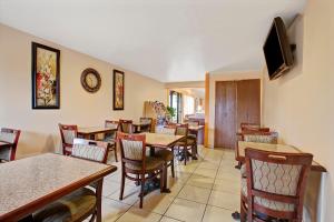 a restaurant with tables and chairs and a flat screen tv at Knights Inn Greensburg in Greensburg