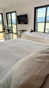 a white bed in a room with windows at Olive Grove Retreat in La Trinité