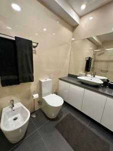 ein Badezimmer mit einer weißen Toilette und einem Waschbecken in der Unterkunft Central Home in Arouca + 14 Fotos