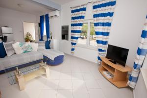 ein Wohnzimmer mit Sofa und Fernseher in der Unterkunft G&G apartments in Zadar
