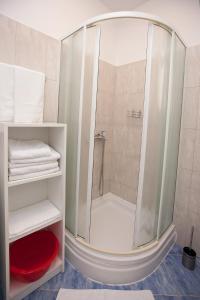 ein Bad mit einer Dusche und weißen Handtüchern in der Unterkunft G&G apartments in Zadar